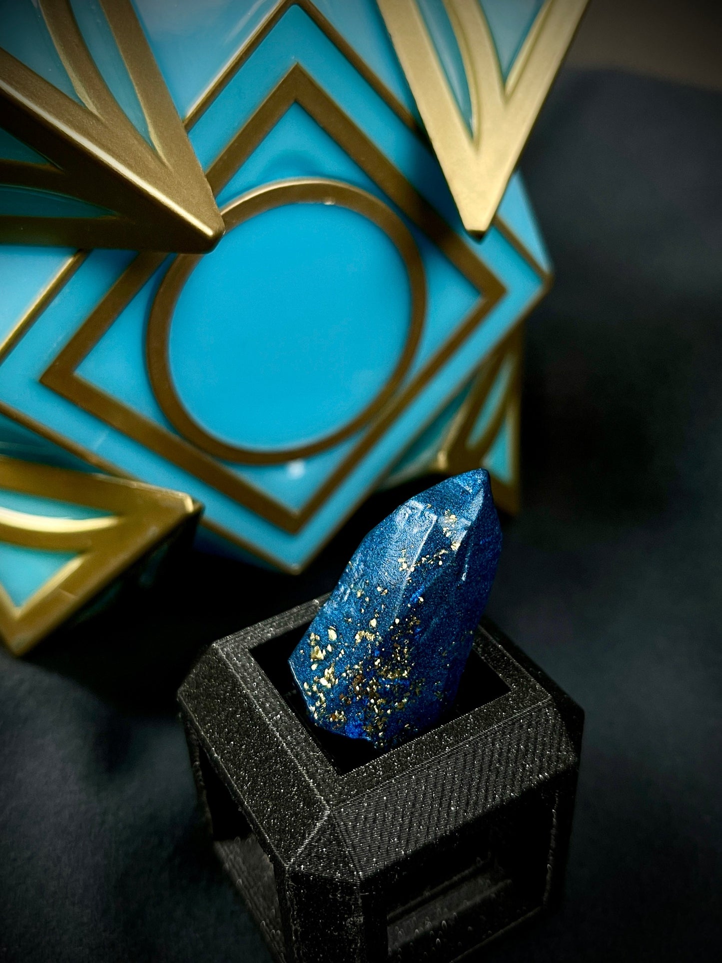 Stardust Crystal, Blue Savi's kyber crystal with gold flakes. In front of Jedi Holocron